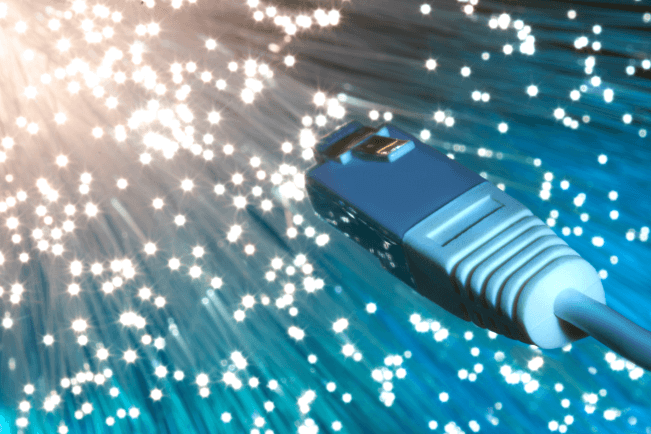 Closeup on the end of optical fiber network cable on blue